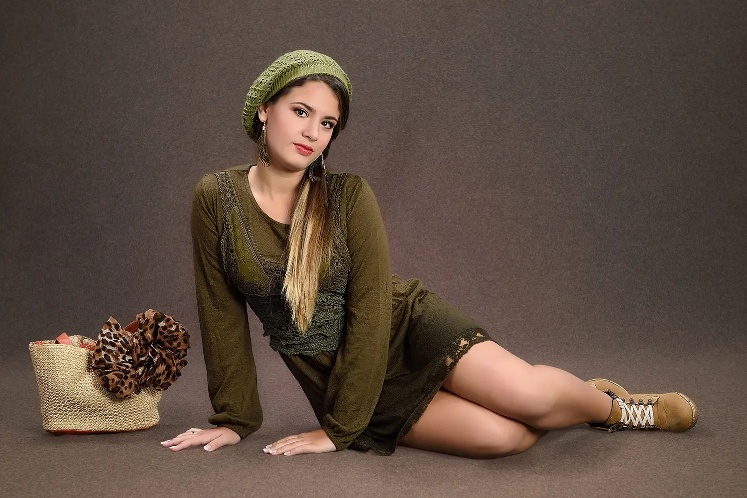 Muchacha con cartera sentada sobre suelo color marrón