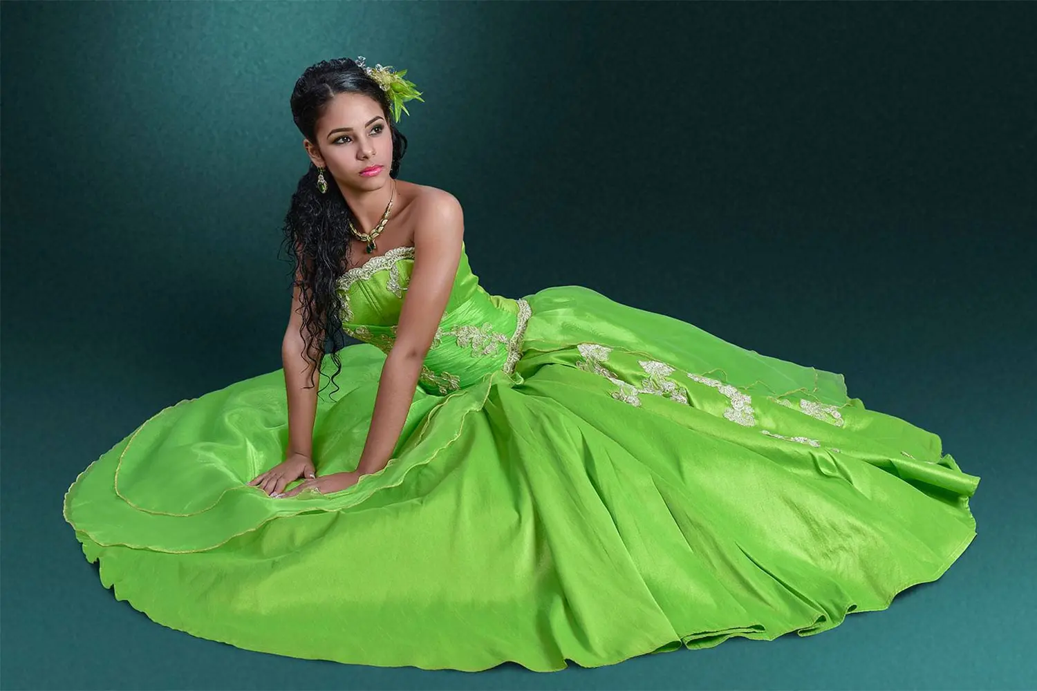 Modelo sentada en el suelo con vestido verde de fantasía