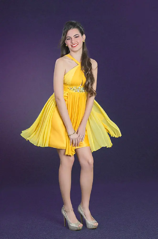 Chica contenta posando con vestido corto amarillo