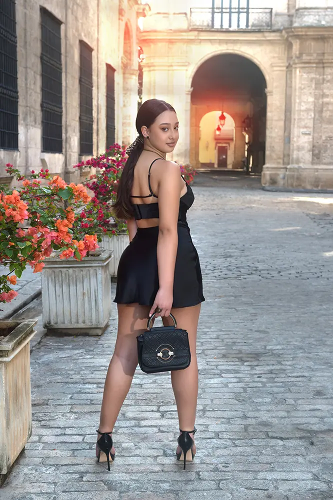 Modelo de espaldas mirando a cámara con fondo de edificio colonial