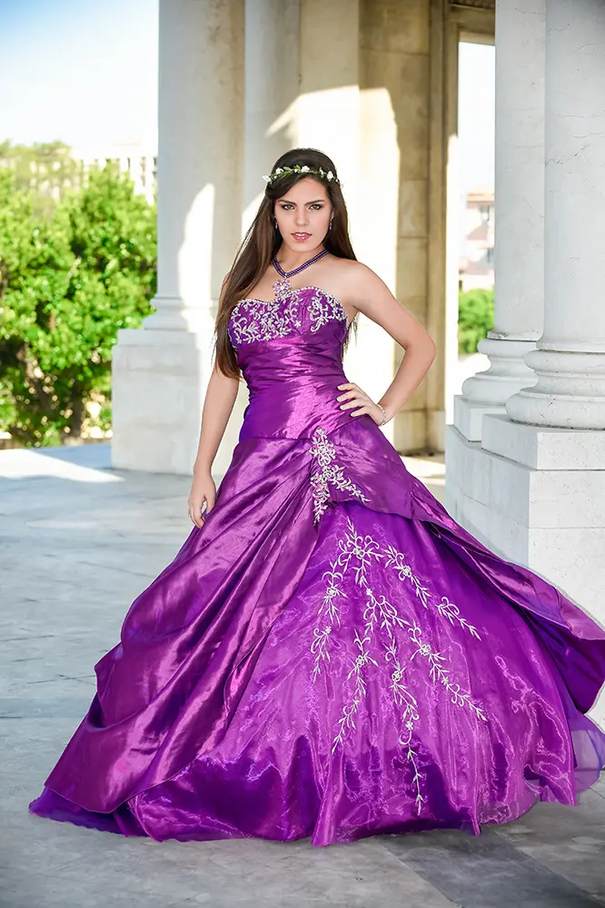 Quinceañera elegante con traje violeta en mausoleo