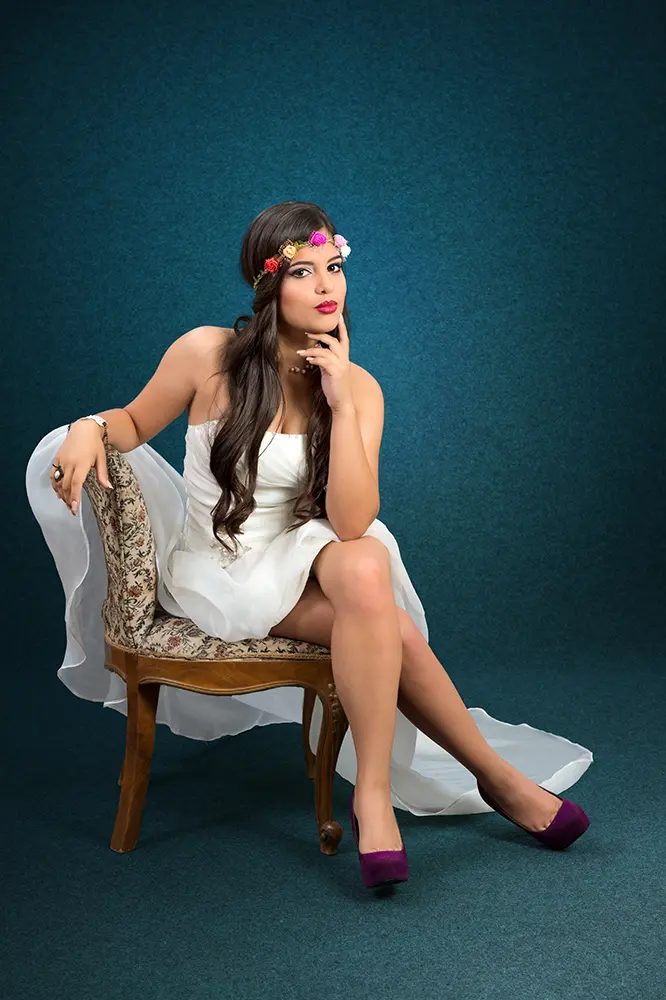 Chica en pose sentada con vestido largo blanco