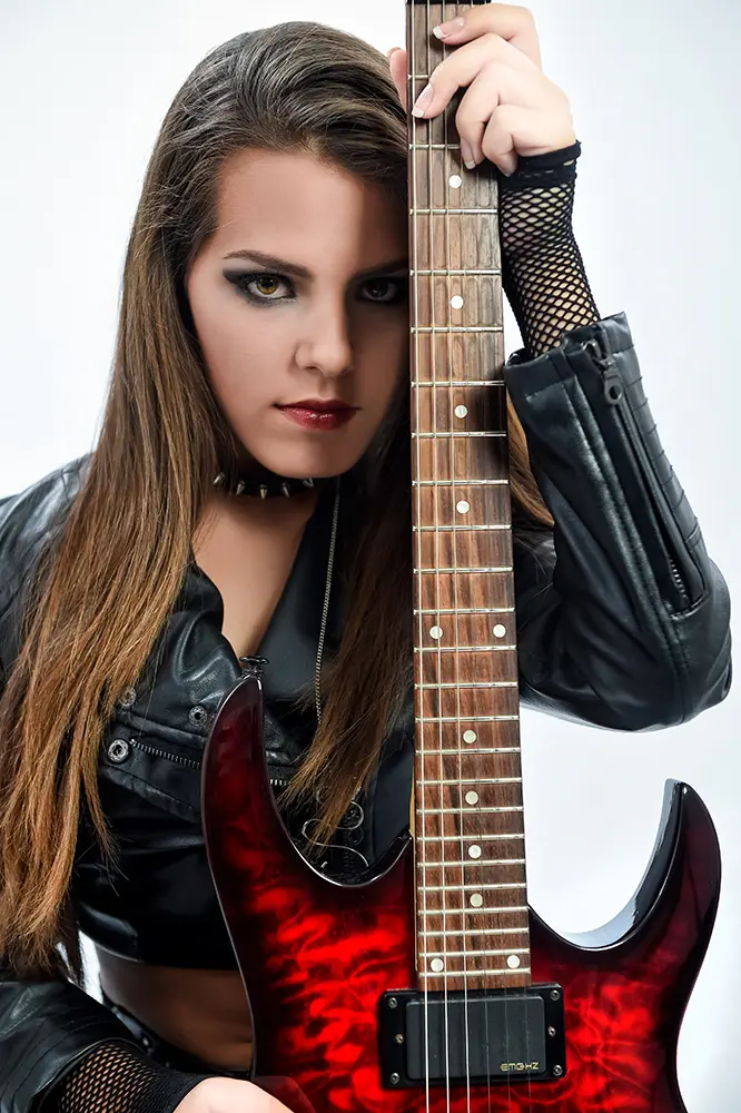 Chica en actitud rockera con guitarra eléctrica roja